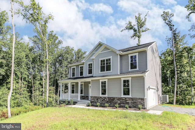 craftsman-style home featuring a porch, central AC unit, a garage, stone siding, and a front lawn