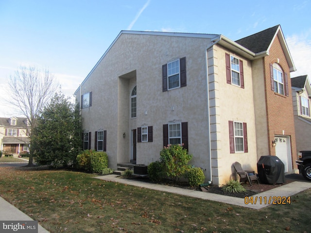 view of front of home with a front yard and a garage