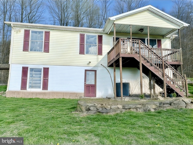 rear view of house with a yard and stairway