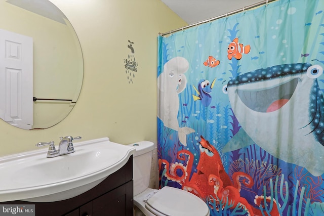 bathroom with toilet, vanity, and a shower with curtain