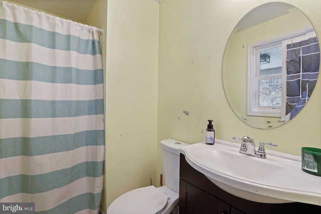 full bathroom with curtained shower, vanity, and toilet