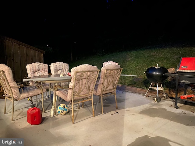 patio at twilight featuring outdoor dining area and area for grilling