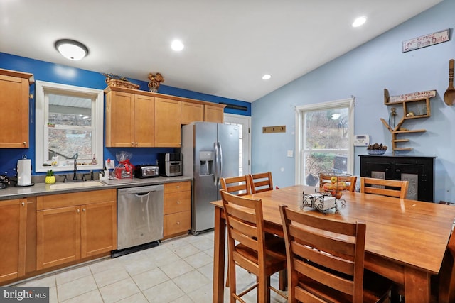 kitchen with light tile patterned floors, lofted ceiling, recessed lighting, appliances with stainless steel finishes, and a sink