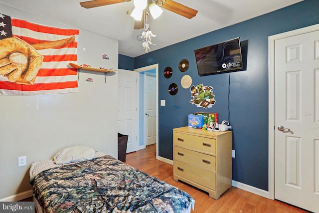 bedroom with a ceiling fan, baseboards, and wood finished floors