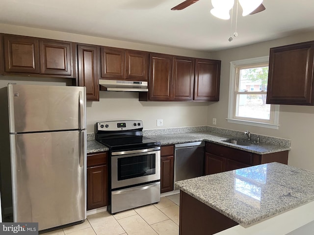 kitchen with ceiling fan, sink, light stone countertops, light tile patterned floors, and appliances with stainless steel finishes