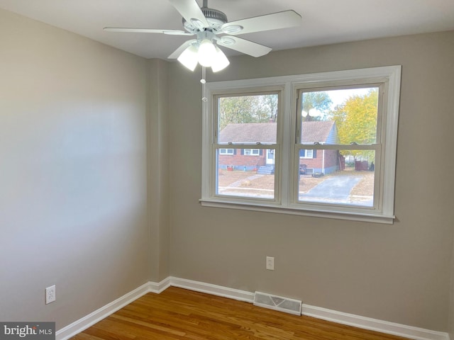 empty room with ceiling fan and hardwood / wood-style floors