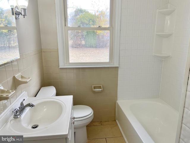 bathroom featuring tile patterned floors, vanity, toilet, and tile walls