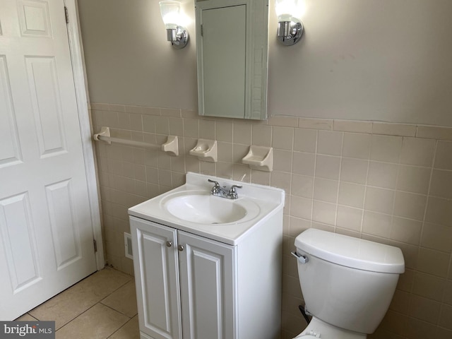 bathroom featuring tile patterned flooring, vanity, toilet, and tile walls