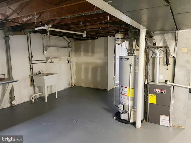 basement with heating unit, sink, and gas water heater