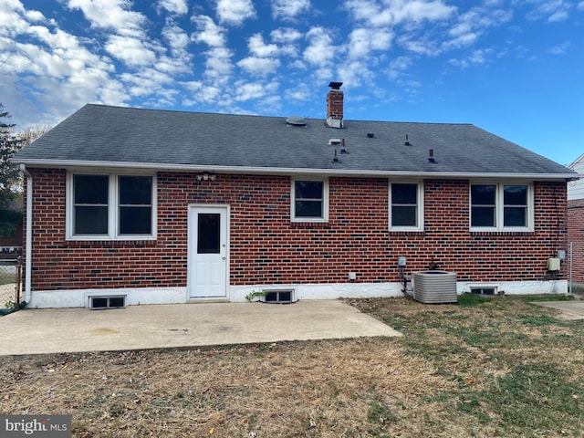 rear view of house featuring a lawn, cooling unit, and a patio