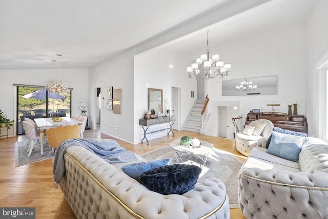 living room featuring a chandelier, light hardwood / wood-style flooring, and high vaulted ceiling