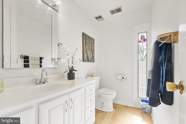 bathroom featuring toilet, hardwood / wood-style floors, and vanity