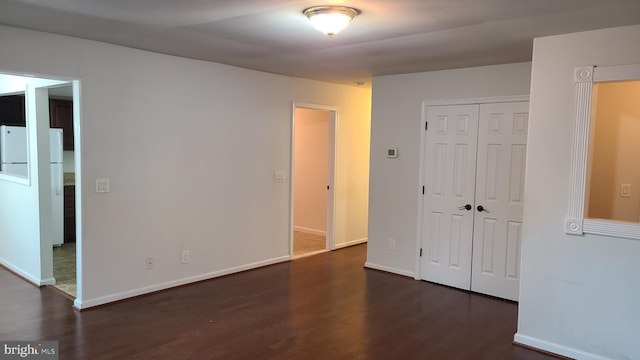 spare room with dark wood-type flooring