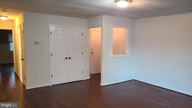 unfurnished bedroom featuring a closet and dark hardwood / wood-style floors