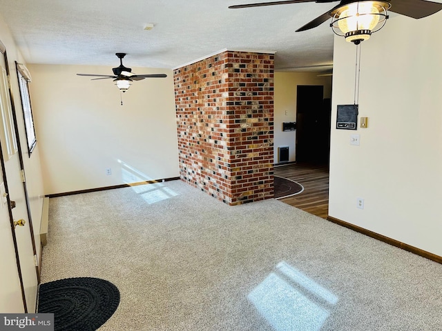 carpeted empty room featuring ceiling fan and a textured ceiling