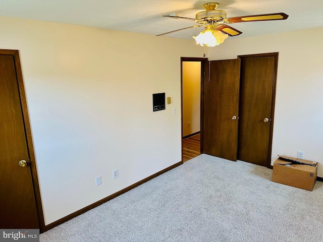 unfurnished bedroom featuring ceiling fan and light carpet