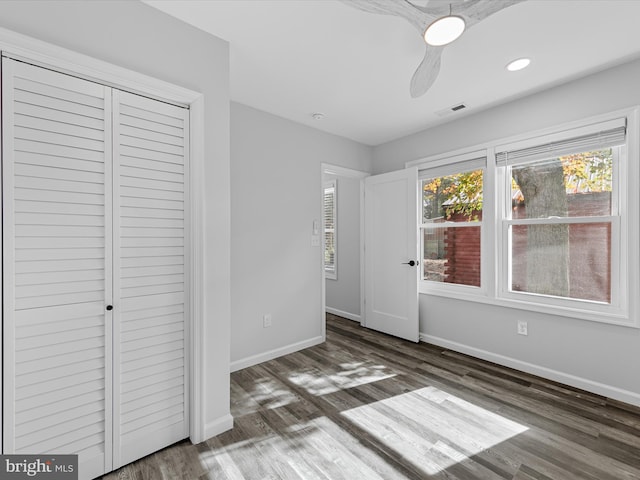 unfurnished bedroom with a closet, ceiling fan, and dark hardwood / wood-style floors