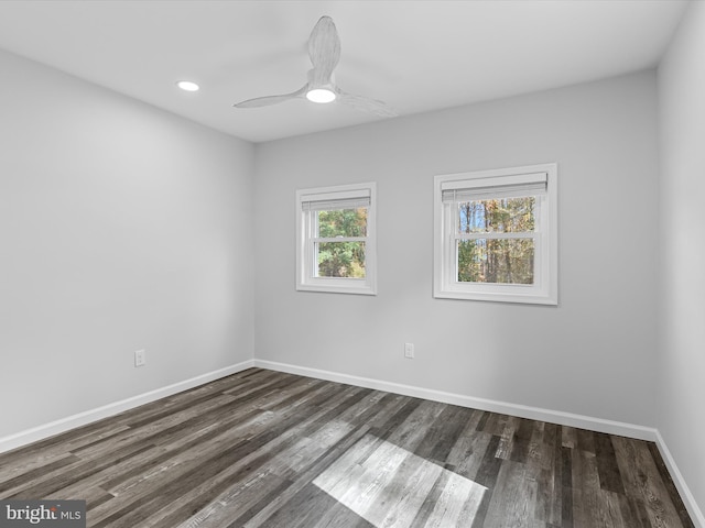 empty room featuring ceiling fan, dark wood-type flooring, and a wealth of natural light