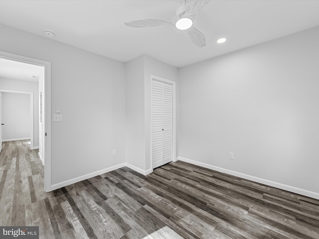 unfurnished bedroom with ceiling fan, dark wood-type flooring, and a closet