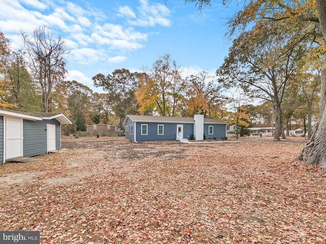 rear view of property with a storage shed