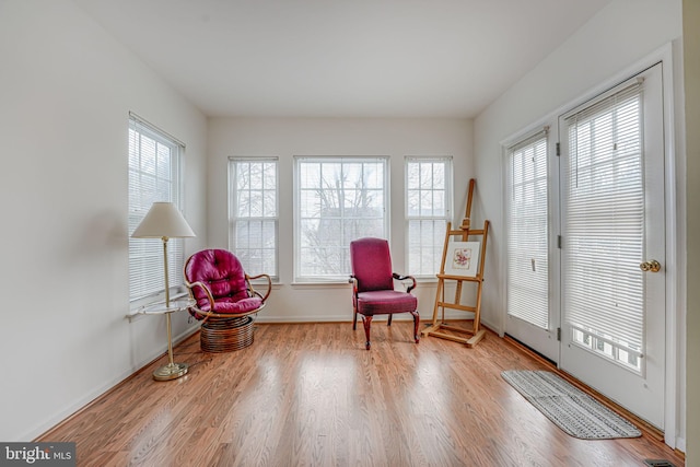 living area with a wealth of natural light and light hardwood / wood-style floors