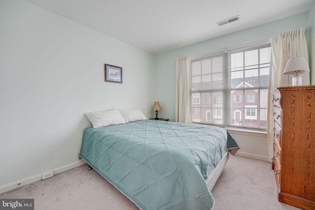 bedroom with multiple windows and light colored carpet