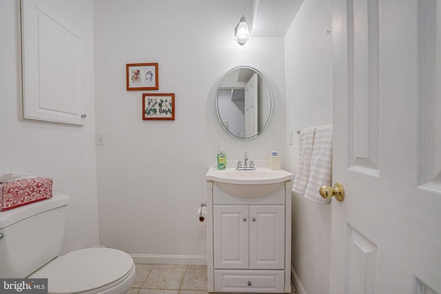 bathroom with toilet, vanity, and tile patterned floors