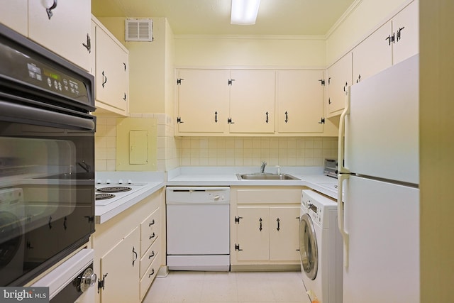 kitchen with white appliances, washer / dryer, sink, and white cabinetry