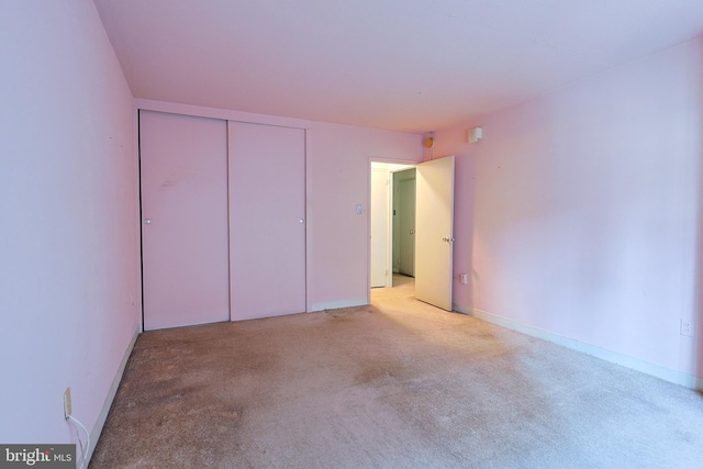 unfurnished bedroom with a closet and light carpet