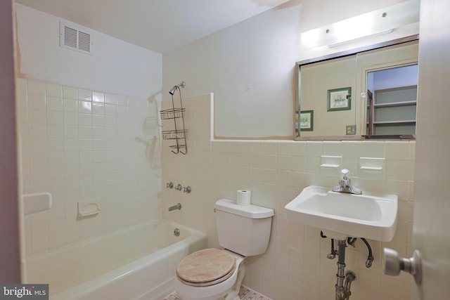 full bathroom featuring sink, toilet, tile walls, and tiled shower / bath combo