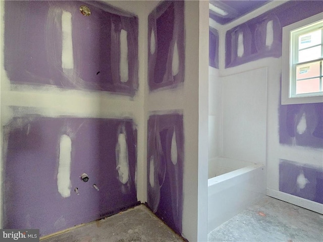 bathroom featuring concrete flooring and a tub