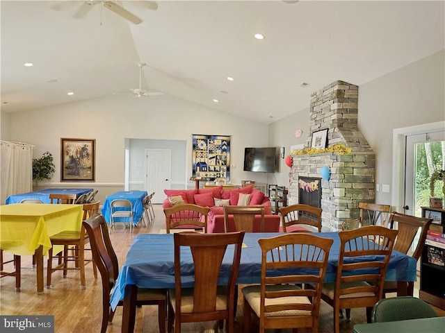 dining area with a fireplace, vaulted ceiling, light hardwood / wood-style flooring, and ceiling fan