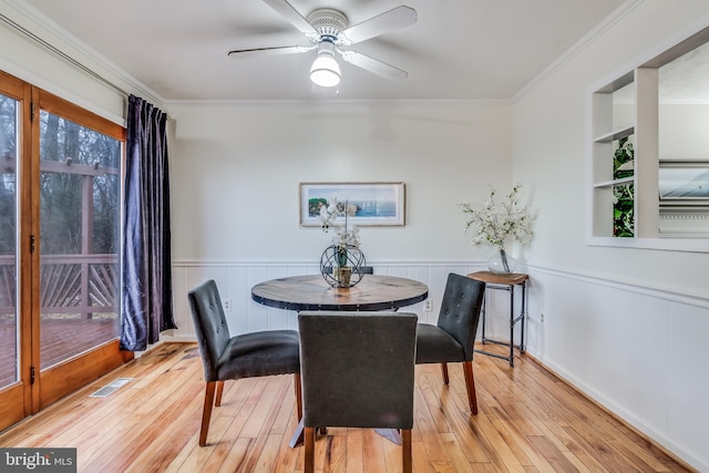 dining space with ceiling fan, ornamental molding, and light hardwood / wood-style flooring