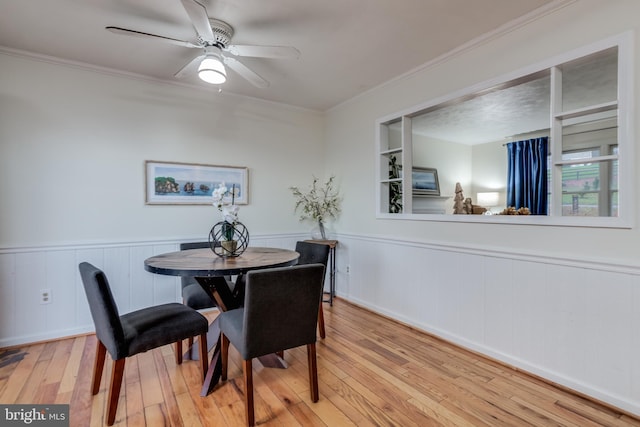 dining room with hardwood / wood-style flooring, ceiling fan, and crown molding