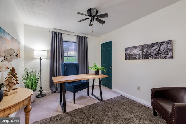 carpeted office space featuring ceiling fan