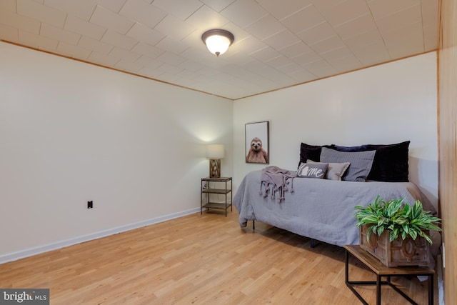 bedroom with light hardwood / wood-style floors and ornamental molding