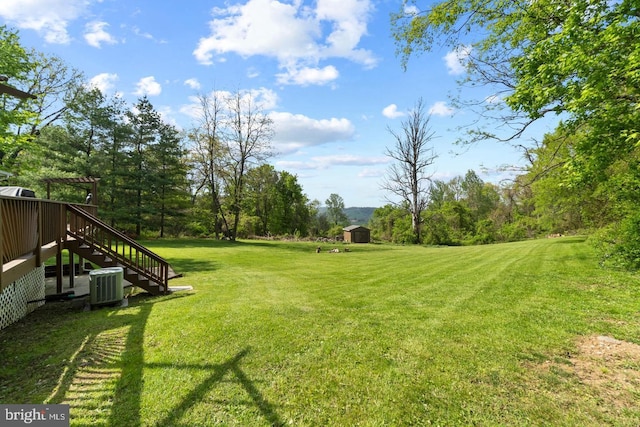 view of yard featuring a deck and central air condition unit