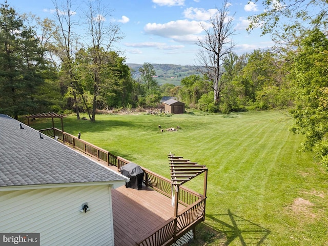 view of yard featuring a wooden deck and a shed