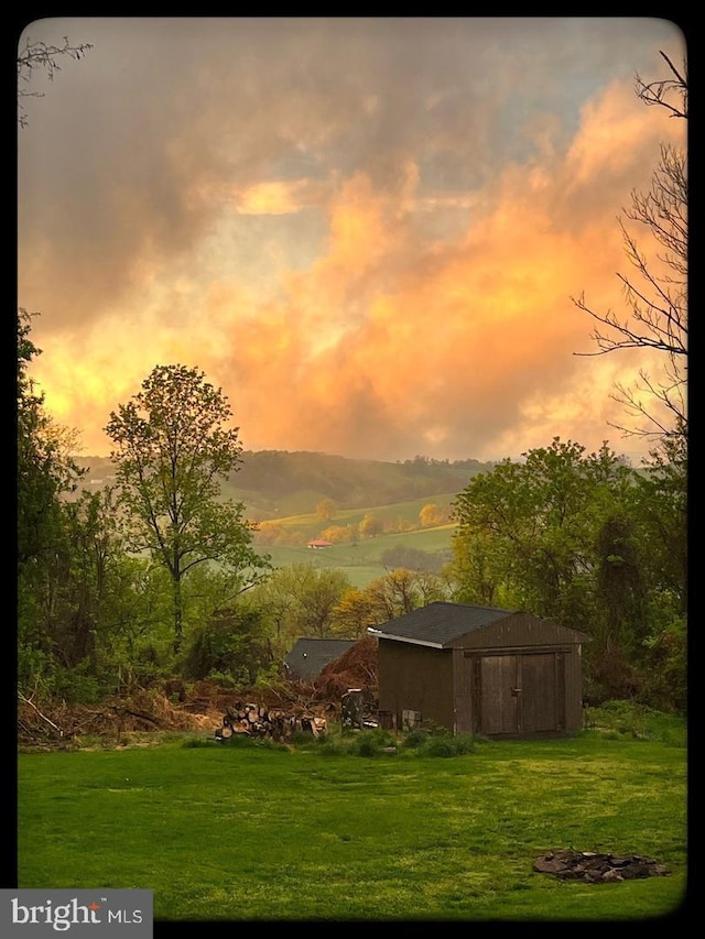 yard at dusk featuring a shed