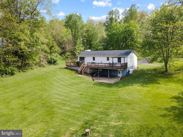 back of property featuring a lawn and a wooden deck