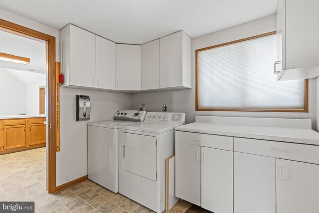 laundry area with cabinets, independent washer and dryer, and a textured ceiling