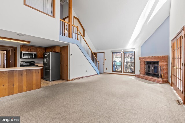 unfurnished living room with light carpet and high vaulted ceiling