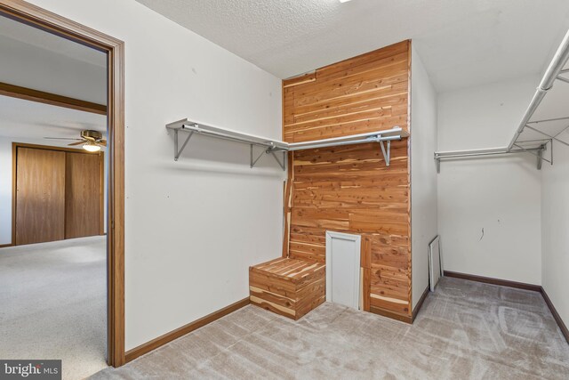 walk in closet featuring light carpet and ceiling fan