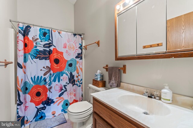 bathroom featuring tile patterned floors, vanity, toilet, and walk in shower