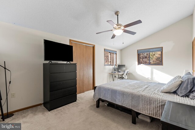 carpeted bedroom featuring a textured ceiling, ceiling fan, and vaulted ceiling