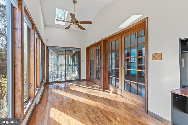 unfurnished sunroom featuring ceiling fan and vaulted ceiling with skylight