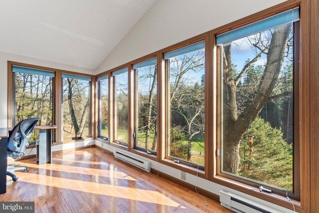 unfurnished sunroom featuring lofted ceiling and a baseboard heating unit