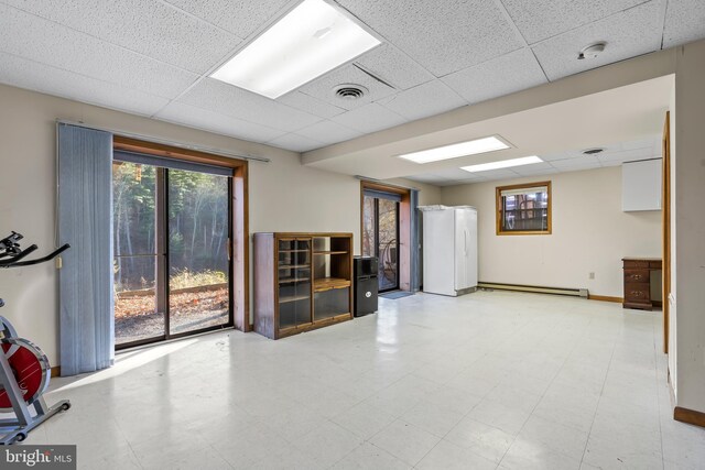 unfurnished room with a paneled ceiling and a baseboard heating unit