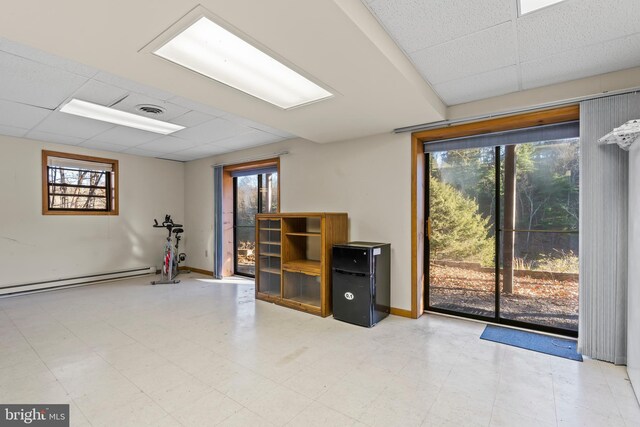 interior space with a paneled ceiling and a baseboard radiator