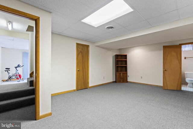 basement with light colored carpet and a drop ceiling